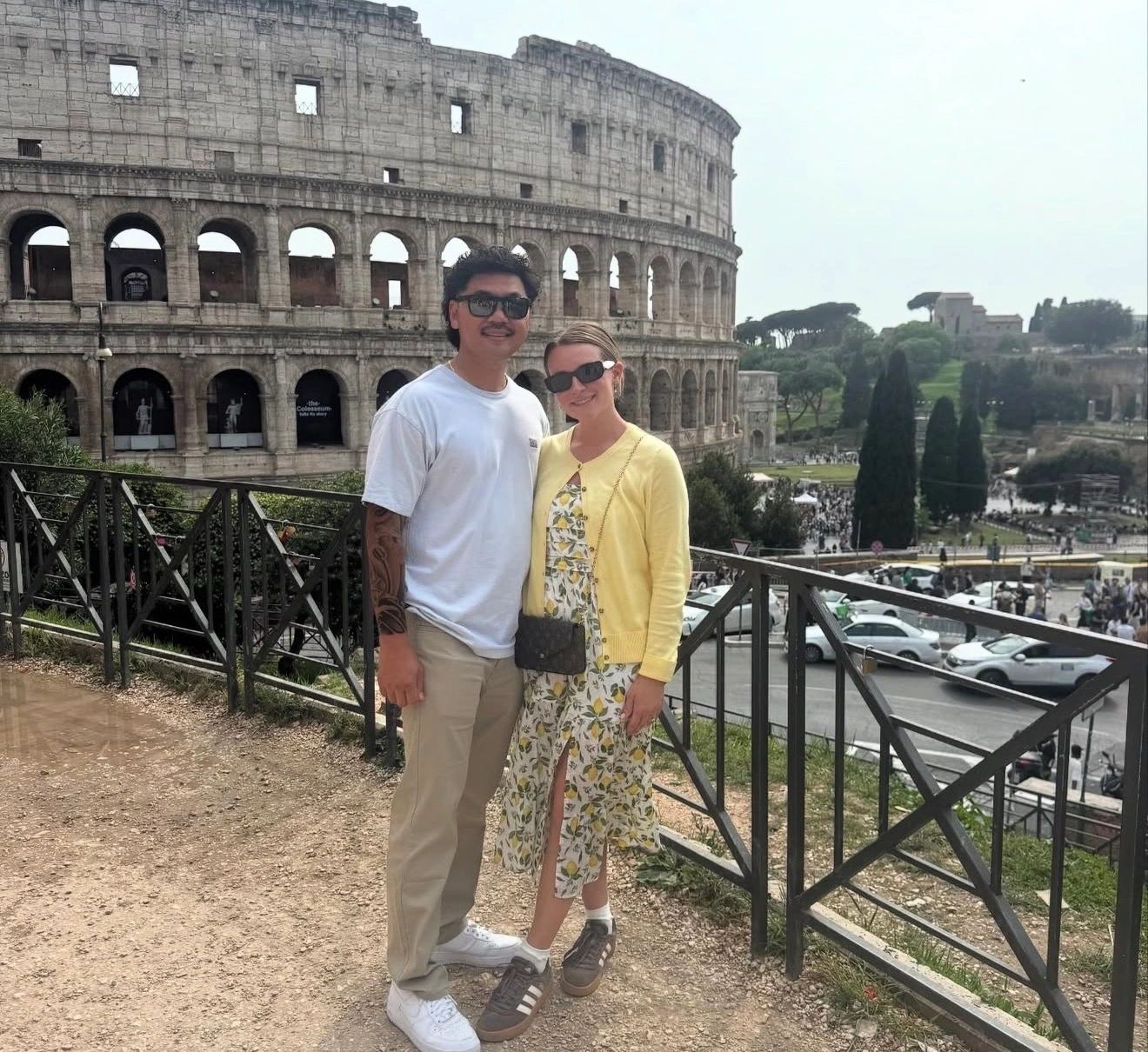 Couple posing in front of the Colosseum.