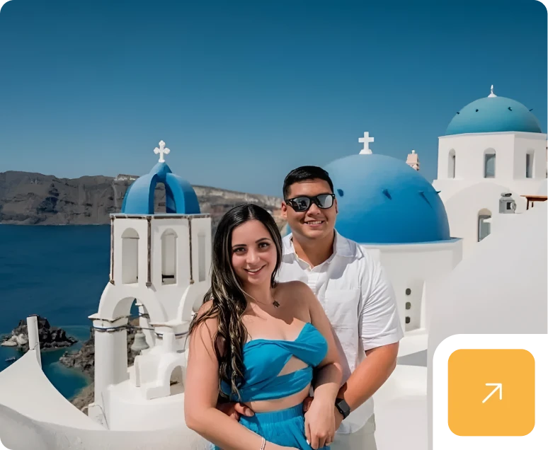 Couple smiling in Santorini with blue domes.