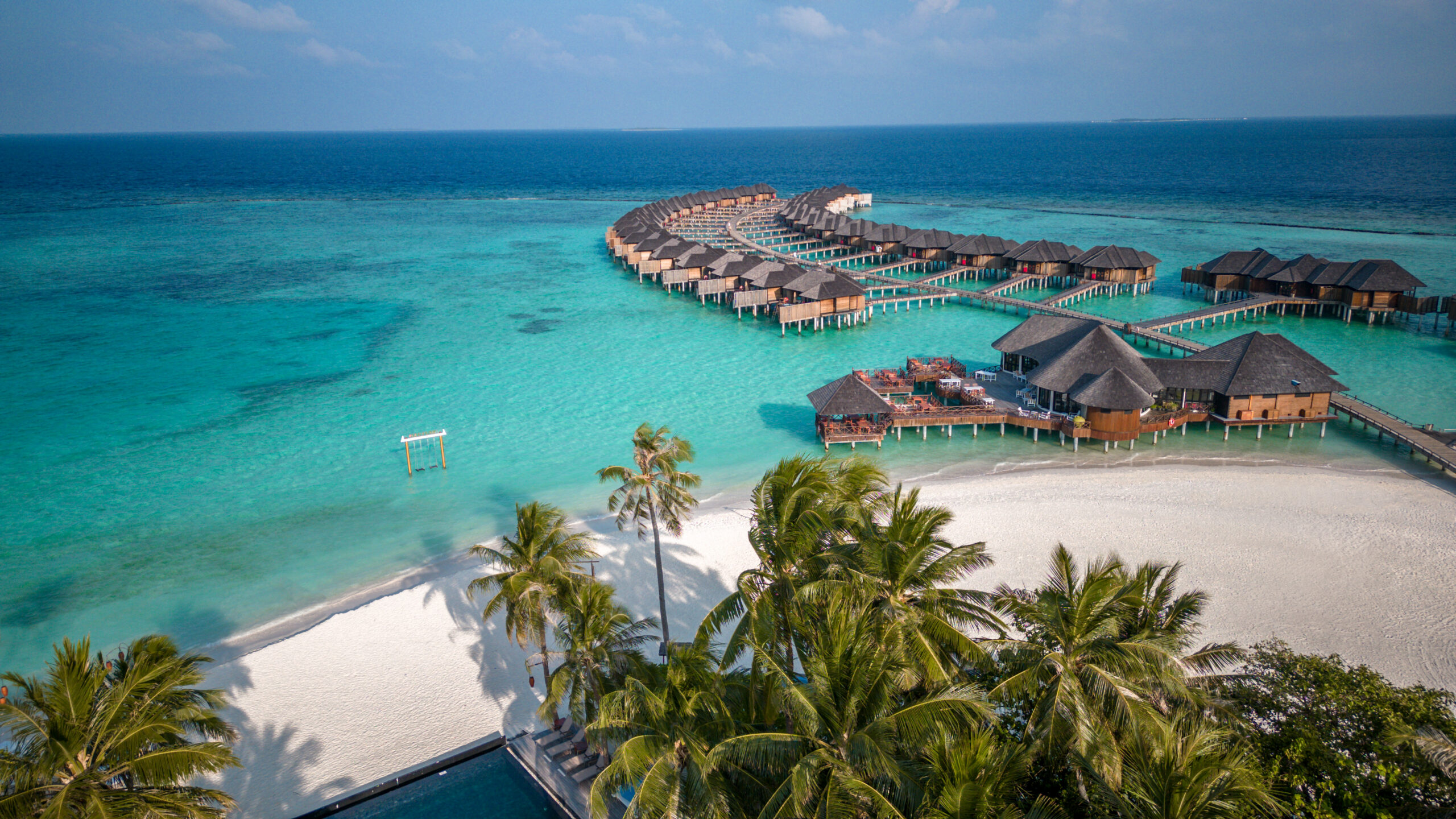 Turquoise ocean with overwater resort bungalows